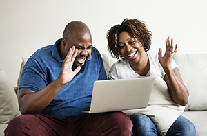 African American couple using a computer to talk with others.